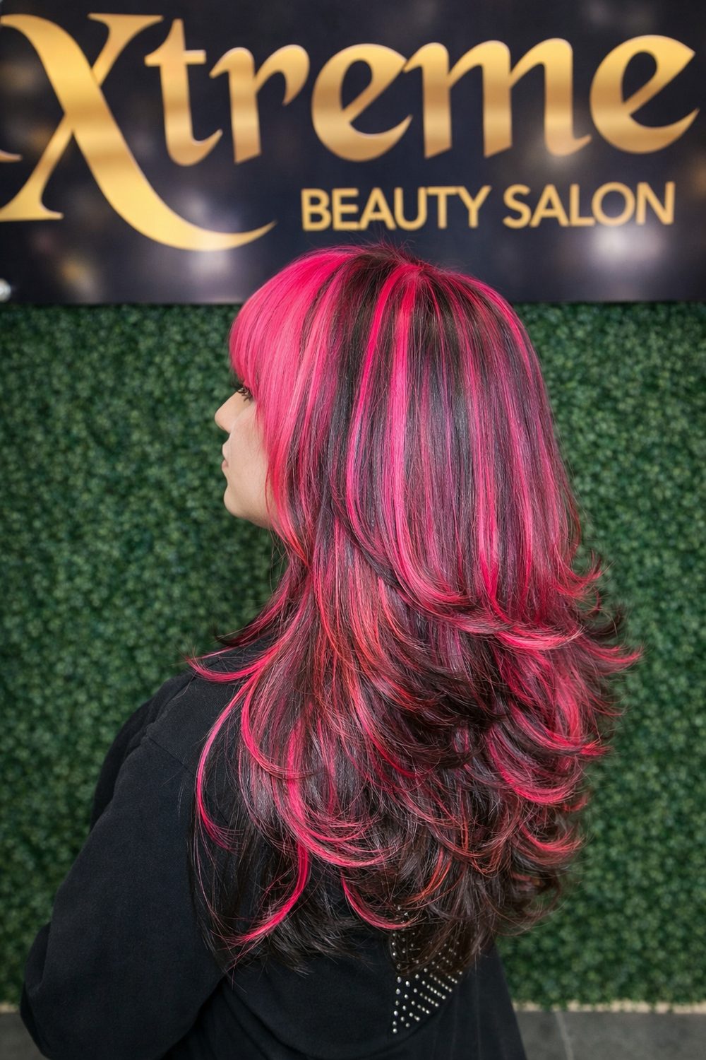 Cabello negro con mechas rosa fucsia y corte en capas